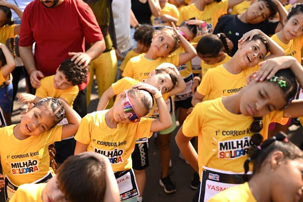 Crianças fazendo alongamento antes da corrida.